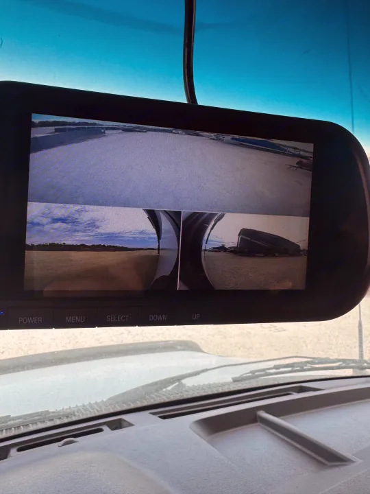 RV rental's multi-camera rear-view mirror display shows wide-angle and split side views, aiding large vehicle maneuvering.. Forest River Sunseeker LE 2023