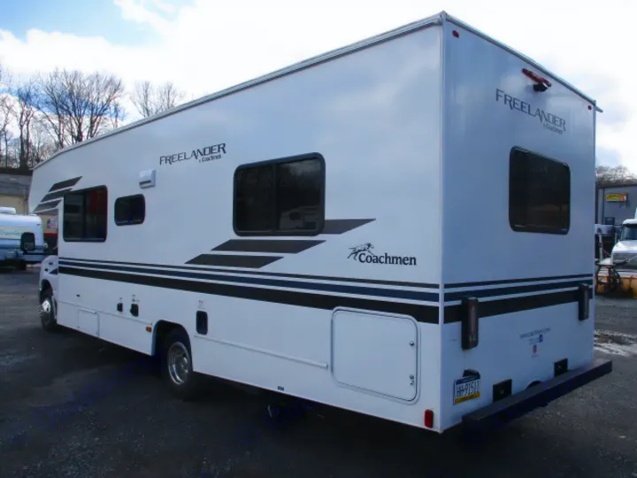 A sleek white Coachmen Freelander RV rental, with black stripe decals, ready for unforgettable journeys.. Coachmen Freelander 2022