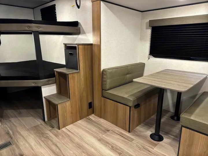 RV rental interior: cozy bunks, dining booth with storage, perfect for family adventures.. Keystone RV Coleman Light 2025