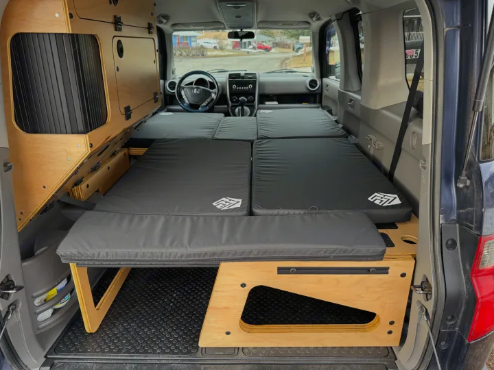 Custom Honda Element camper interior for rv rental, showing wood storage & folding bed mattresses for car camping.. Honda Element 2010