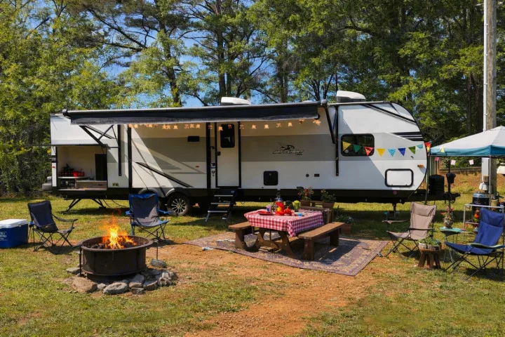 Enjoy this RV rental campsite with a cozy fire pit, picnic table, chairs, and an outdoor kitchen setup under the awning.. Jayco Jay Flight SLX 2025