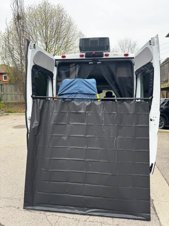 RV rental camper van with rear doors open, featuring a privacy curtain and mesh screen. Ideal for outdoor showers.. Winnebago Solis 2025