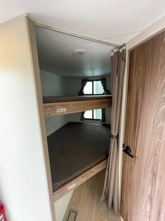 Cozy bunk beds in an RV rental, featuring sleeping areas with windows and a 500 lb capacity, ideal for camper trips.. KZ CONNECT 271BHSE 2026