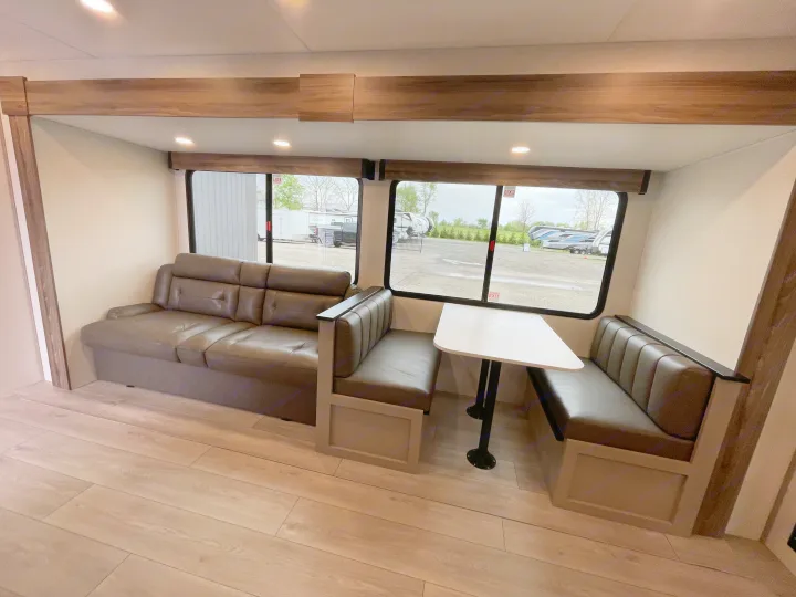 Spacious RV rental interior with a comfy sofa, dinette, light wood floors, and large windows for natural light.. KZ CONNECT 271BHSE 2026