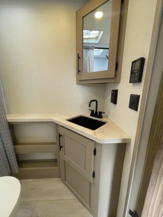 A well-appointed RV rental bathroom featuring a sleek vanity with a black sink, faucet, medicine cabinet, and controls.. KZ CONNECT 271BHSE 2026