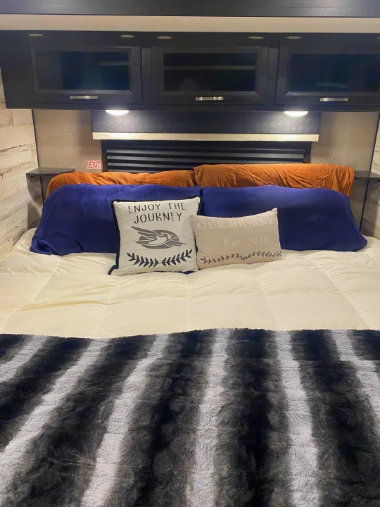 Comfortable rv rental bedroom with a cozy bed, overhead cabinets, and decorative pillows, ready for your next adventure.. Jayco White Hawk 2020