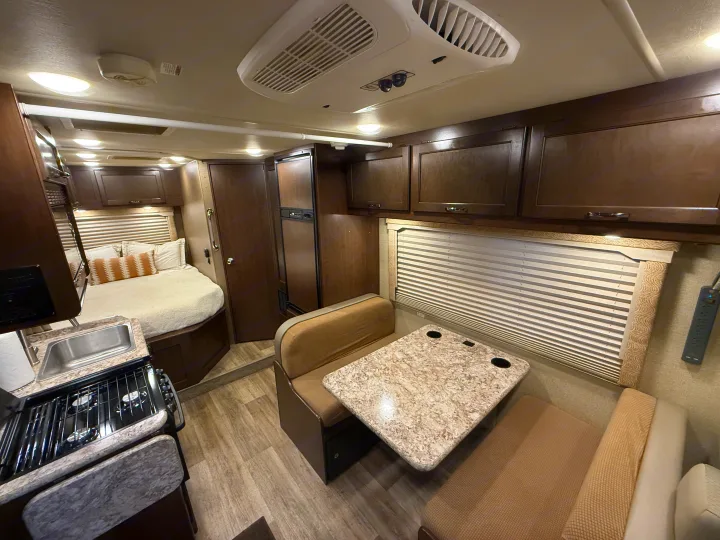 This rv rental offers a full view of its interior with a bed, kitchenette, dinette, and overhead cabinets for storage.. Thor Freedom Elite 2017