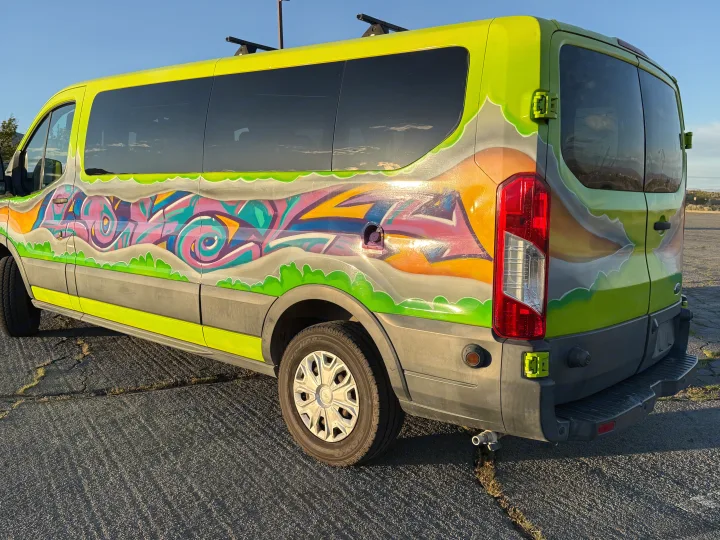 Vibrant RV rental van with unique graffiti art on its lime green exterior, showcasing a dynamic custom design.. Ford Transit 2017