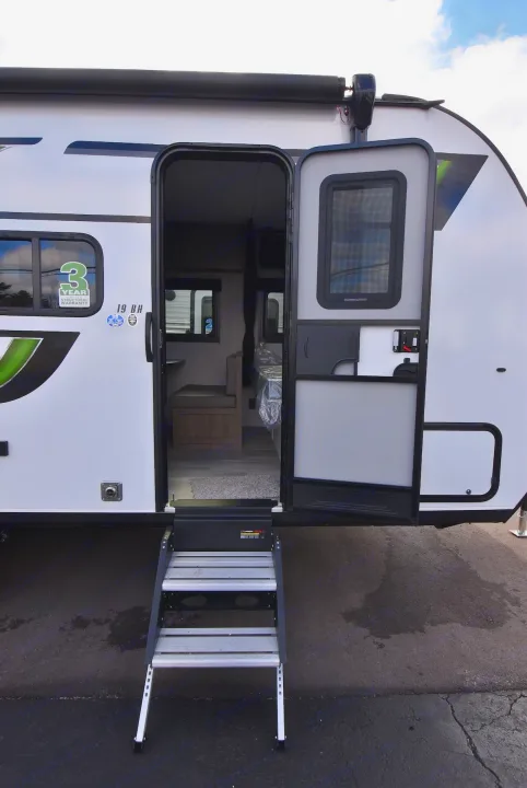 Step inside this RV rental! A white travel trailer with its door open, showing entrance steps and a partial view of the interior.. Starcraft Autumn Ridge 2025