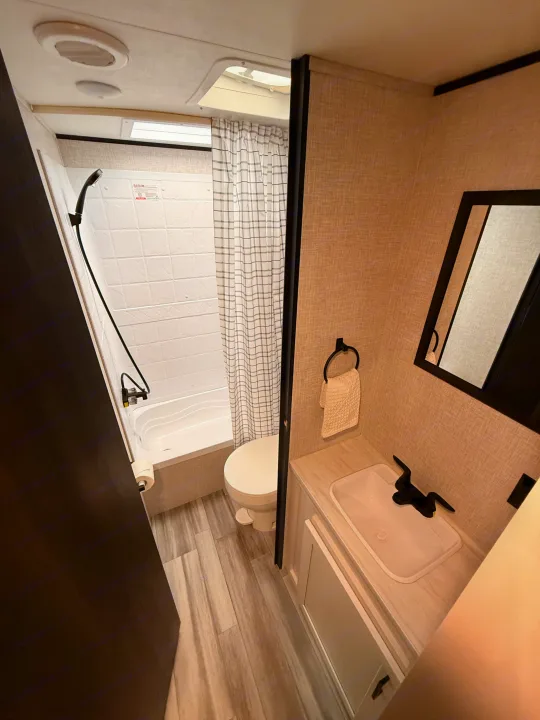 Functional RV rental bathroom with a shower/tub, toilet, sink vanity, and modern finishes. Perfect for travel.. Jayco Jay Flight SLX 2024
