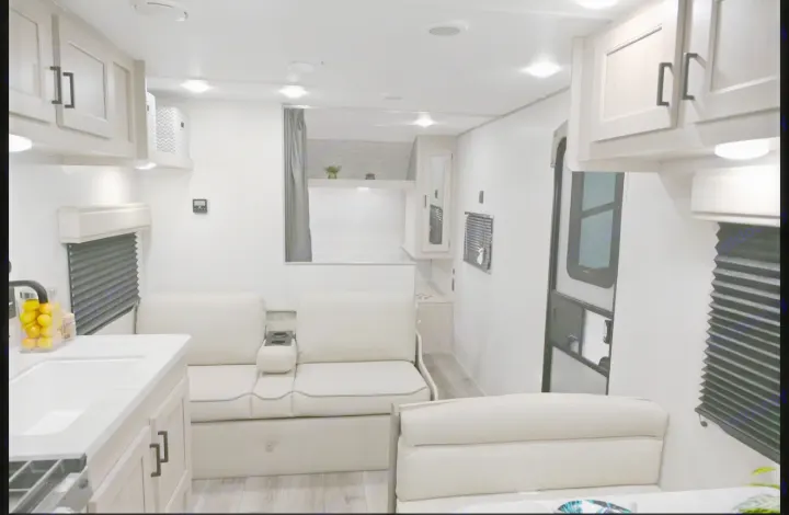 Bright, modern RV rental interior featuring a compact kitchen, comfortable seating, and bunk beds for travel.. Coachmen Catalina 2025