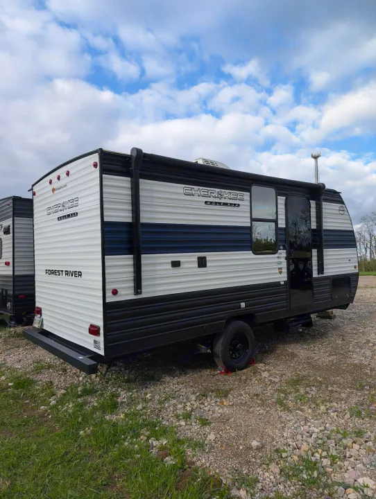 A white & black Cherokee Wolf Pup travel trailer, ideal for your next RV rental adventure. Parked on gravel under a cloudy sky.. Forest River Cherokee Wolf Pup 2025