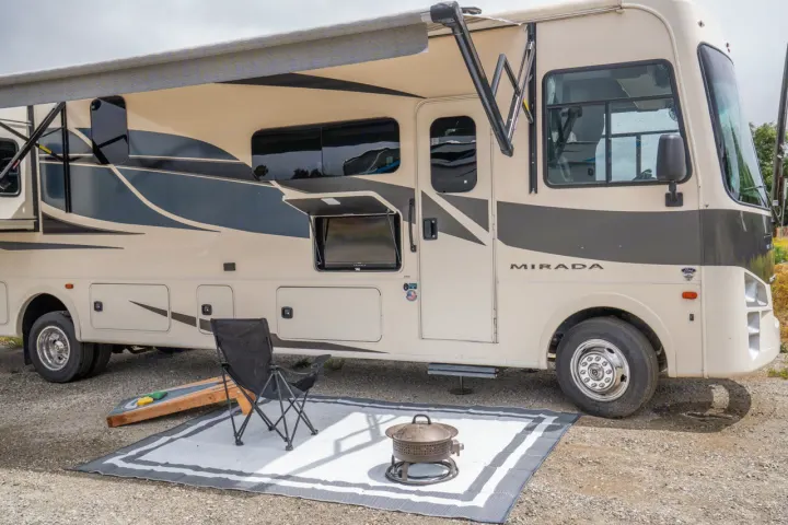 RV rental: Mirada motorhome parked with awning out, outdoor TV, rug, chair, fire pit, and cornhole board ready for camping.. Forest River Coachmen Mirada 2022