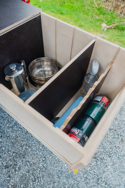 RV rental camping storage: Organized drawer holds a French press, pots, spray, and Coleman propane, ready for outdoor trips.. Toyota Hiace 2005