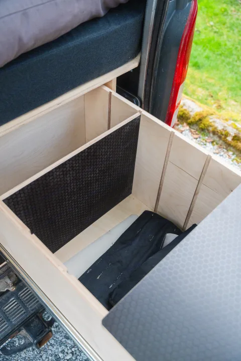 RV rental: View inside custom wooden storage with internal dividers, a black textured anti-slip panel, and stored items.. Toyota Hiace 2005