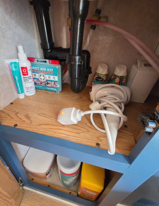 RV rental under-sink area: first aid, hygiene products, hairdryer, air fresheners, and cleaning supplies, efficiently stored.. Sunline Solaris 2002