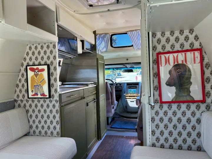 Cozy and personalized RV rental interior with custom sloth and 'DOGUE' art, featuring a compact kitchen.. Roadtrek 190 Popular 1995