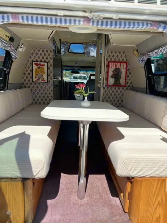 Stylish rv rental interior: dining booth with striped cushions, patterned walls, and fun artwork. Ready for your journey.. Roadtrek 190 Popular 1995
