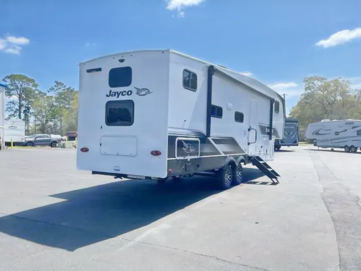 A white Jayco travel trailer, ideal for rv rental, is seen from the rear and side in a sunny outdoor lot.. Jayco Eagle Super Lite 2025