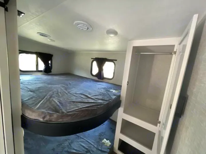 This rv rental offers a cozy RV bedroom with a spacious platform bed, multiple windows, and a practical closet.. Jayco Eagle Super Lite 2025