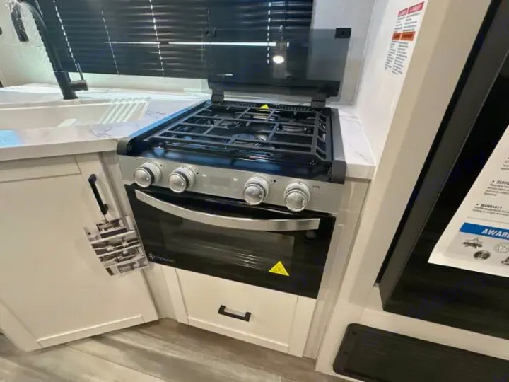 This RV rental's sleek kitchen boasts a stainless steel stove/oven, sink, and ample white counter space, ready for your adventures.. Jayco Jay Flight 2026