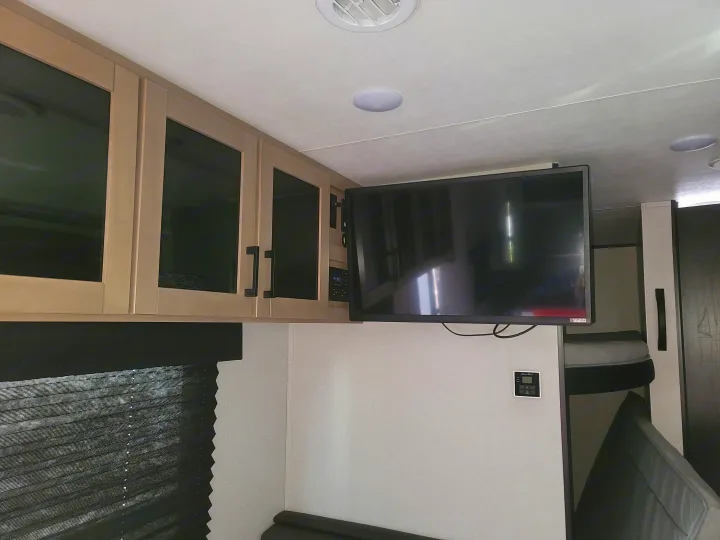 RV rental interior featuring overhead cabinets, a mounted TV, and bunk beds. Ideal for family trips.. Jayco 260BH 2026
