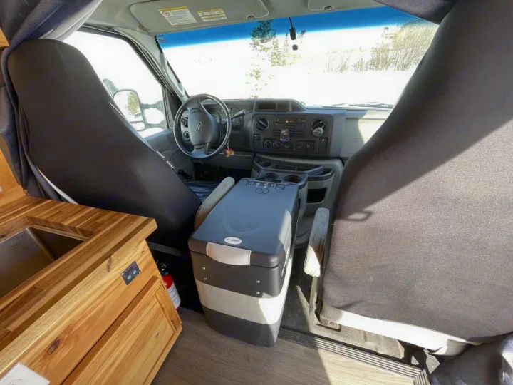 Inside this RV rental: driver's area, portable fridge, and kitchenette with sink. Perfect for your next road trip adventure.. Gmc Savanna 2500 2016