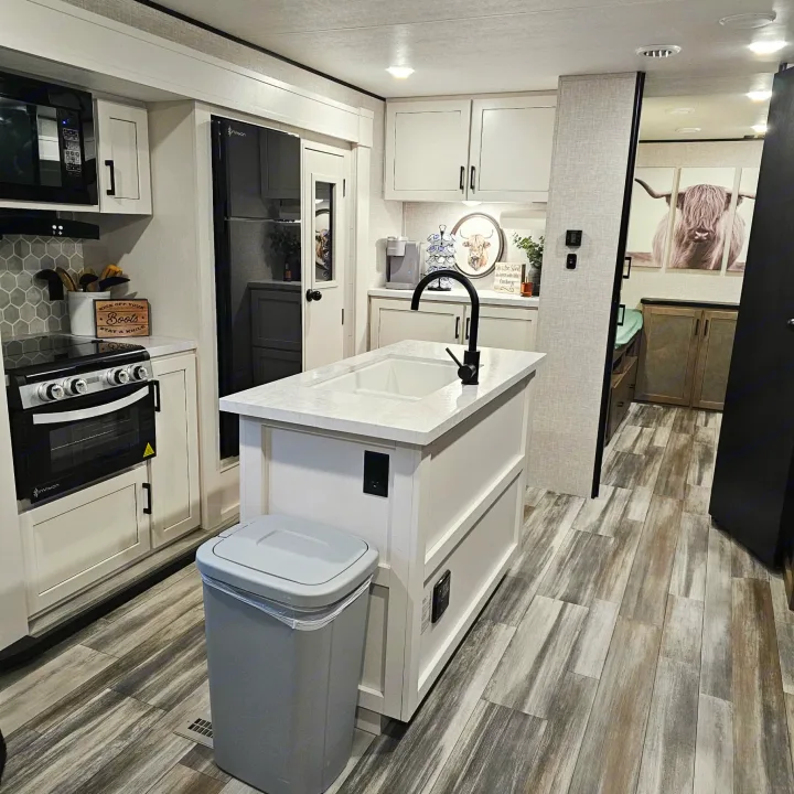 Cozy RV rental kitchen with a modern design, island sink, and full appliances. Rustic decor adds warmth to the interior.. Jayco SLX 2025