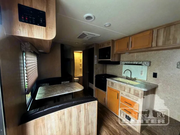 Inside this RV rental: a cozy dinette, a functional kitchen with sink/stove/microwave, and a private bathroom in the rear.. Coachmen Other 2020