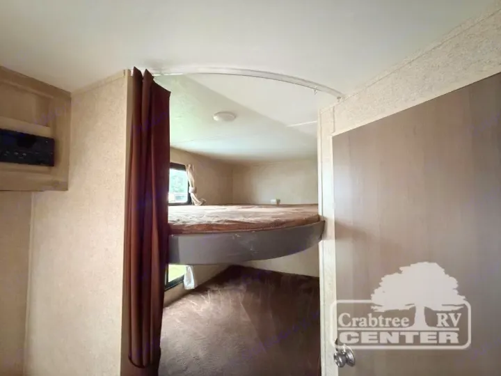 RV rental interior: bunk beds, a brown privacy curtain, an entertainment unit, and a door with the Crabtree RV Center logo.. Coachmen Other 2020