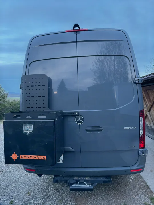 Gray Mercedes Sprinter 2500 4x4 rv rental, with a custom rear storage box, gear rack, and Sync Vans branding.. Mercedes Sprinter 2020