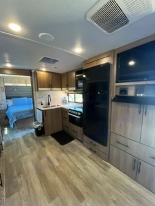 Modern RV rental interior with a fully equipped kitchen, living area, and cozy bedroom. Ideal for your next adventure!. Grand Design Imagine 2022