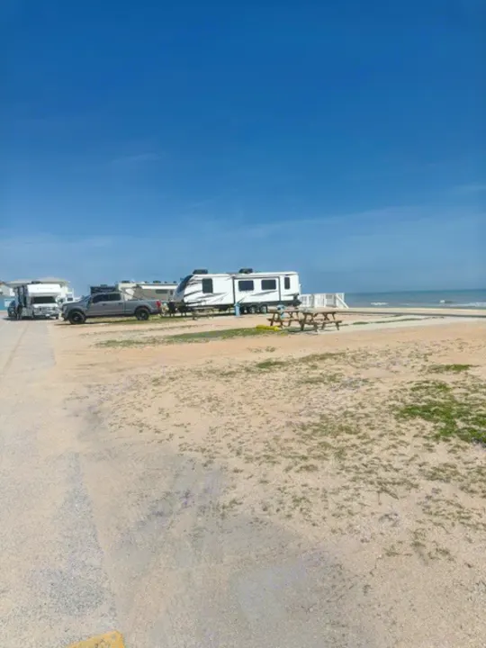 RV rental vehicles parked at a sunny beachside campsite with the ocean in the background.. Keystone RV Bullet Premier Ultra Lite 2022