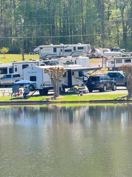 Lakeside RV park with many RVs, some under awnings, by a calm lake. People relax. Great setting for an rv rental.. Keystone RV Bullet Premier Ultra Lite 2022