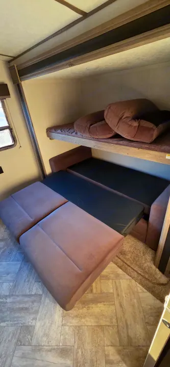 Inside this RV rental, find a space-saving design with a top bunk and a pull-out sofa bed on the lower level.. Keystone RV Springdale 2021