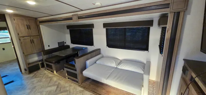 Cozy RV rental interior: features a convertible dinette, sofa, and storage for comfortable travels and adventures.. Keystone RV Springdale 2021