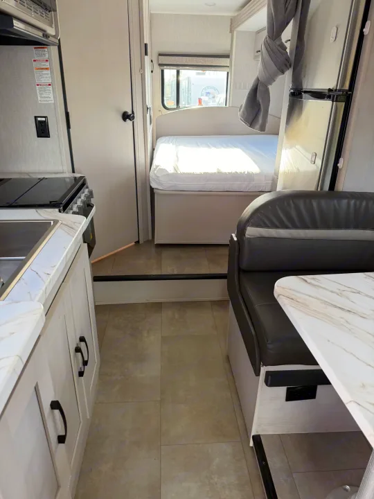 Inside this bright **rv rental**, discover a modern kitchen, cozy bed, and comfortable dinette area.. Forest River Coachmen Freelander 2023