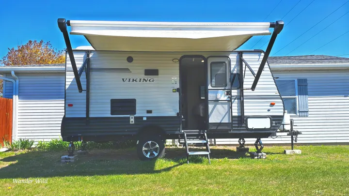 Parked Viking travel trailer with awning extended and door open. Ready for your next rv rental adventure or camping trip.. Forest River Viking 2018