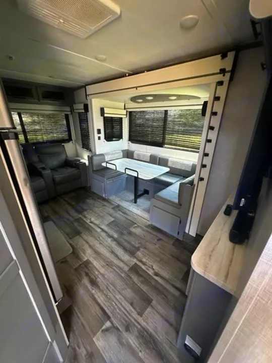 Explore this RV rental's inviting interior: dinette, comfy seating, bunk bed, and wood-look flooring. Ready for adventure!. Crossroads RV Volante 2022
