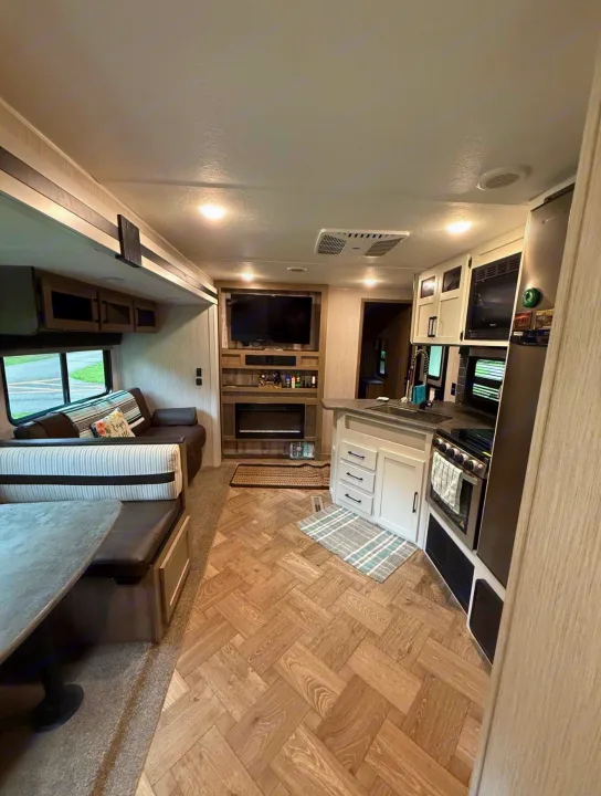Explore this inviting rv rental interior, showcasing a full kitchen, comfy living area, and dining dinette.. Forest River Palomino Puma 2022