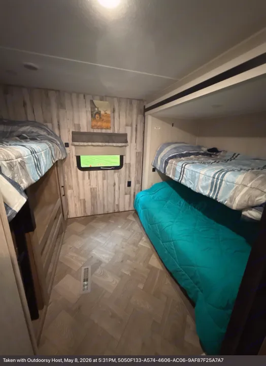 Compact RV rental bunk room, featuring cozy bunk beds with striped bedding and a light wood-look interior.. Forest River Palomino Puma 2022