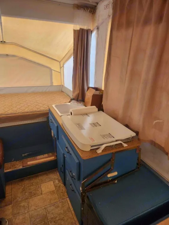 Step inside this cozy rv rental pop-up camper: a compact kitchen with a sink and cooktop, plus a comfy bed for adventures.. Forest River Rockwood Freedom 2009