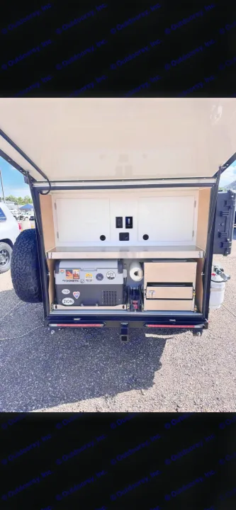 This rv rental features a compact outdoor kitchen in a trailer, with a Dometic fridge, stainless counter, and storage drawers.. Boreas MXT 2020