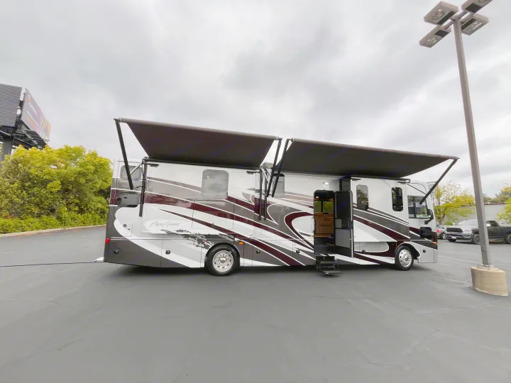 A large, multi-colored Pace Arrow motorhome with awnings extended for an rv rental, parked on asphalt.. Fleetwood Pace Arrow 2020