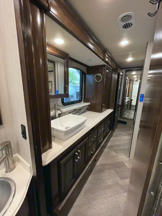 Modern RV rental vanity & bathroom with dark wood cabinetry, vessel sink, and sleek design.. Fleetwood Pace Arrow 2020