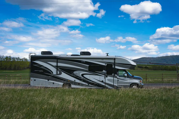 Sleek Greyhawk Prestige RV rental parked by a grassy field under blue skies. Ideal for memorable road trips.. Jayco Greyhawk Prestige 2021
