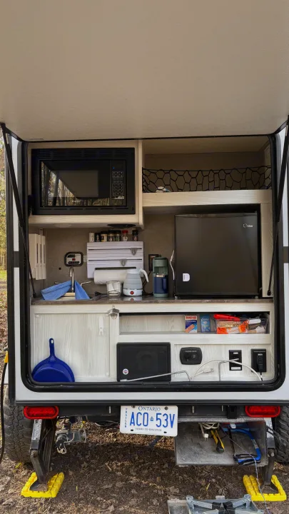 Explore this rv rental's compact exterior kitchen! Features microwave, fridge, sink, and organized camping essentials.. Forest River Rockwood Geo Pro 2018