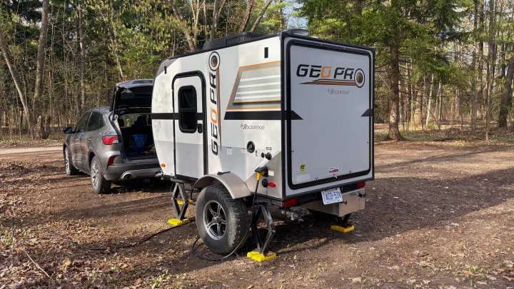 Geo Pro by Rockwood travel trailer, possibly an rv rental, parked in a wooded setting with an SUV.. Forest River Rockwood Geo Pro 2018