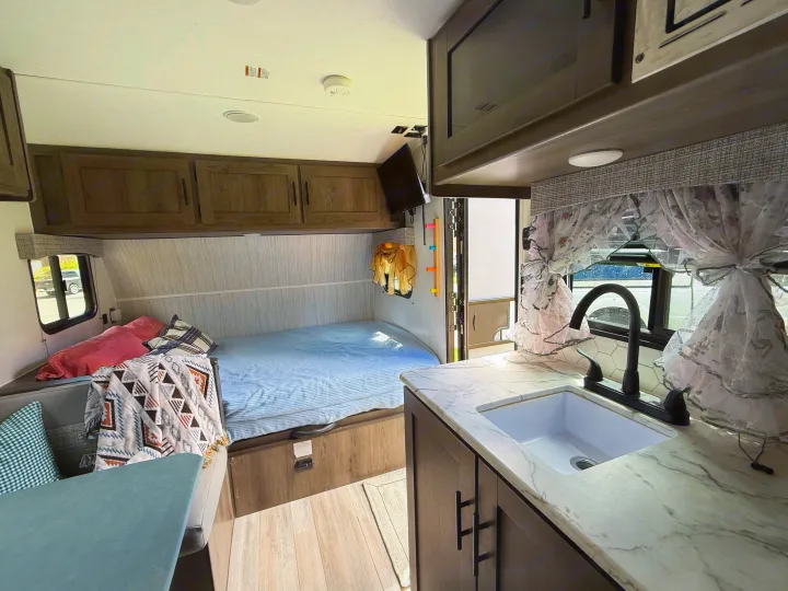 rv rental: Bright interior with a bed, kitchen sink, and cozy living area, ideal for comfortable road trips.. Coachmen 17BH 2022