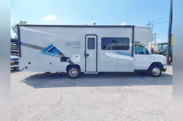 Side view of a white and gray Class C rv rental, parked outdoors on concrete. Features a blue and black 'SPRINTER TRAIL' graphic.. Coachmen Crosstrail 2023